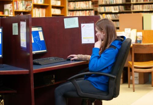 A teen patron uses the public computer.