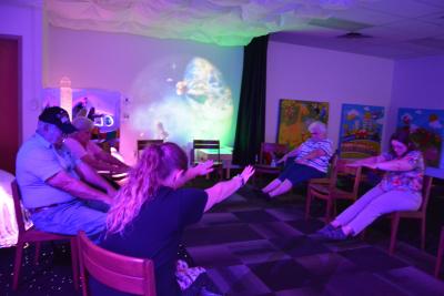 Seniors do chair yoga with Miss Tracey in the Sensory Space.